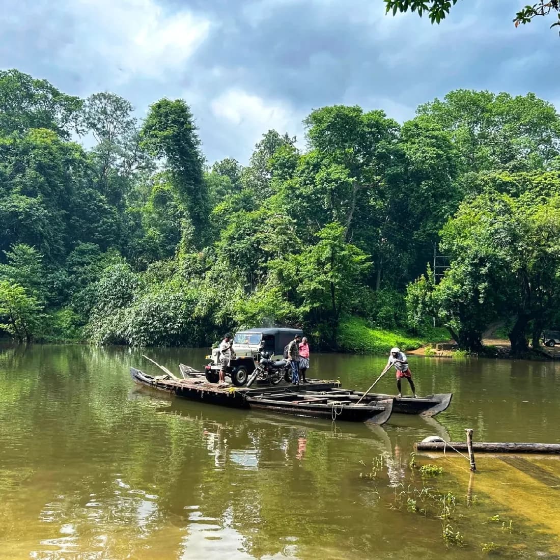 A boat on the river beside the green banks of Kuttampuzha
